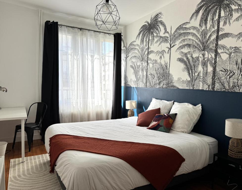 une chambre avec un grand lit avec un mur bleu dans l'établissement Appartement 40m2 - Hyper Centre, à Brest