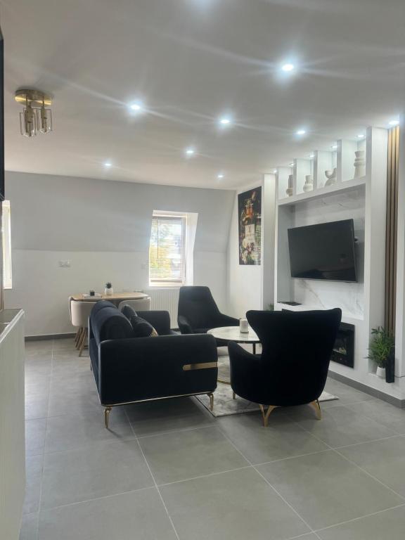 un salon avec un canapé, des chaises et une télévision dans l'établissement By cité de la gastronomie, à Dijon