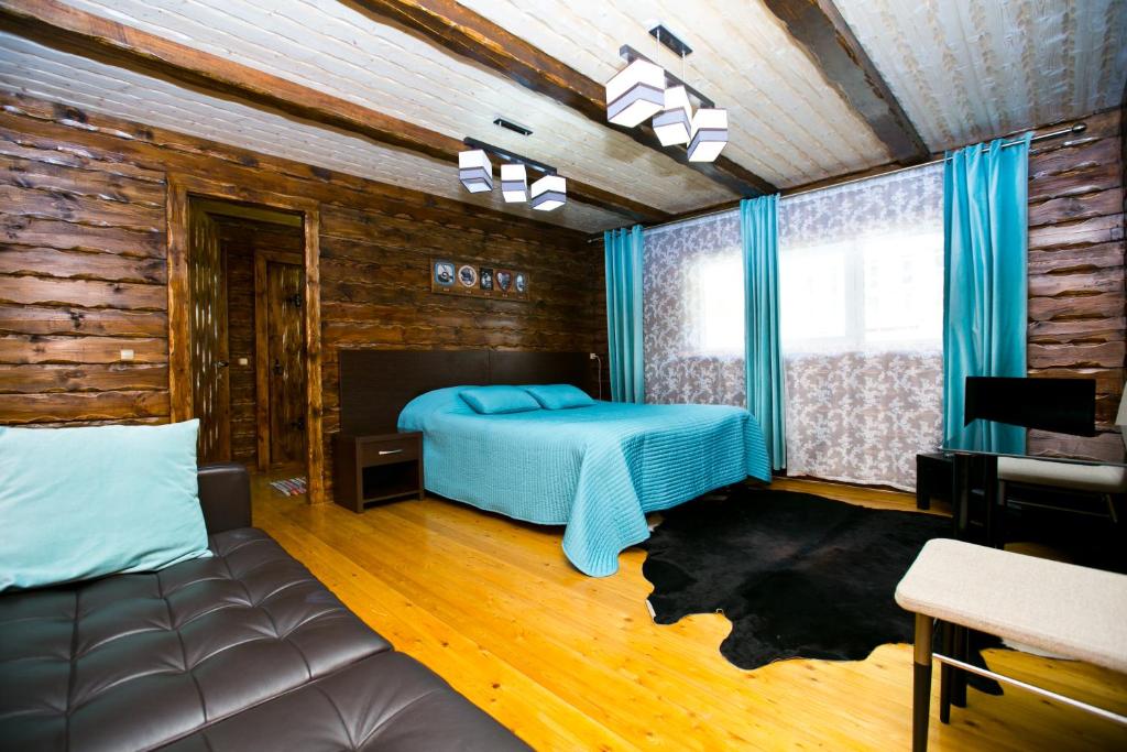 een slaapkamer met een bed en een bank bij Cherepanovs' Guest House in Esto-Sadok