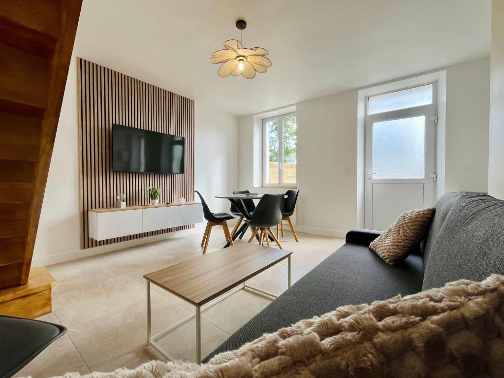 a living room with a couch and a table at La Rose des Marais - Renovated & Fully Equipped House in Houesville