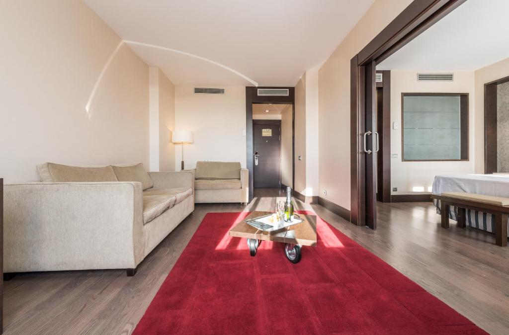 sala de estar con sofá y alfombra roja en Hotel Mercader, en Madrid