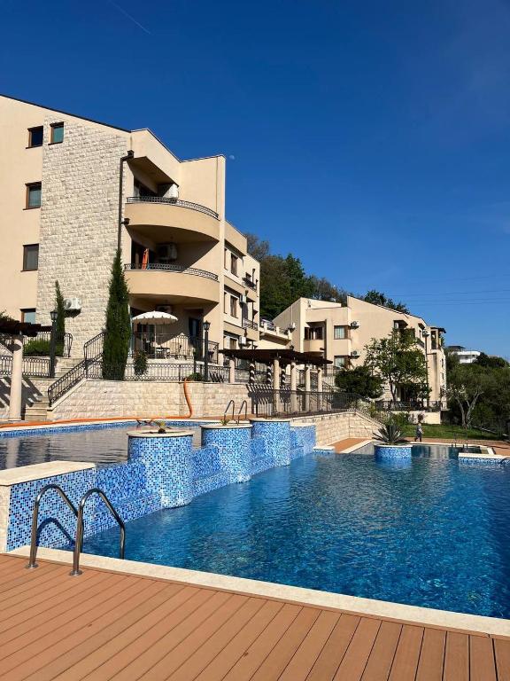 a large swimming pool in front of a building at Adria Mare one bedroom apartment in Tušupi