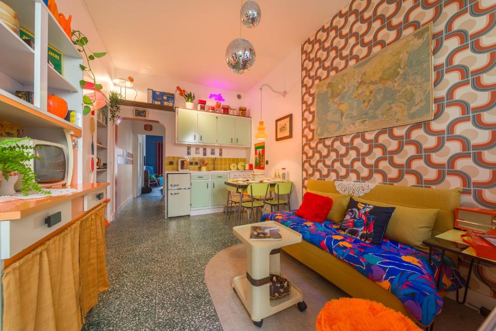 un salon avec un canapé et une cuisine dans l'établissement Les Seventies - Confort Vintage proche gare, à Chambéry