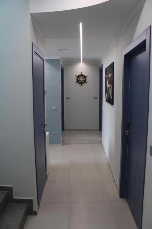 a hallway with two blue doors and a tile floor at Dimora Saracena in Termoli
