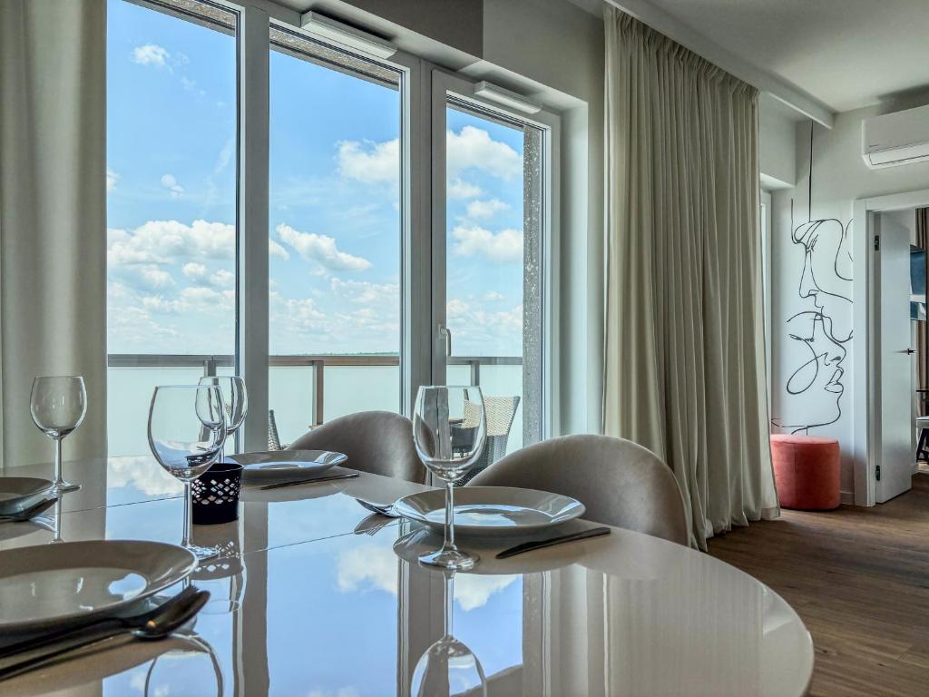 Un comedor con mesa y sillas y una gran ventana. en URBAN APARTMENTS Global Premium 13th Floor No 24 Free Garage Self Check-in, No Deposit, en Katowice