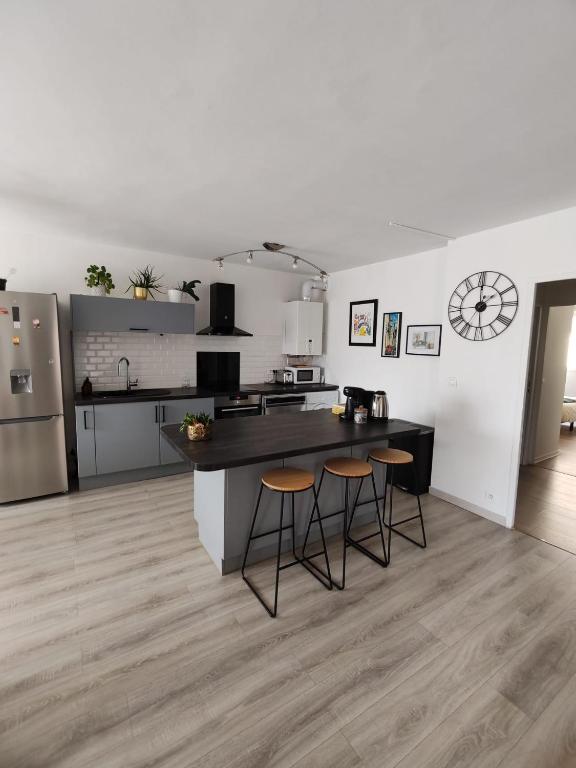 une cuisine avec un comptoir et des tabourets dans une pièce dans l'établissement les Clés du lys, à Périgueux