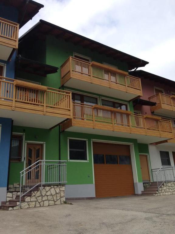 a green building with wooden balconies on top of it at Appartamento Emma in Faver