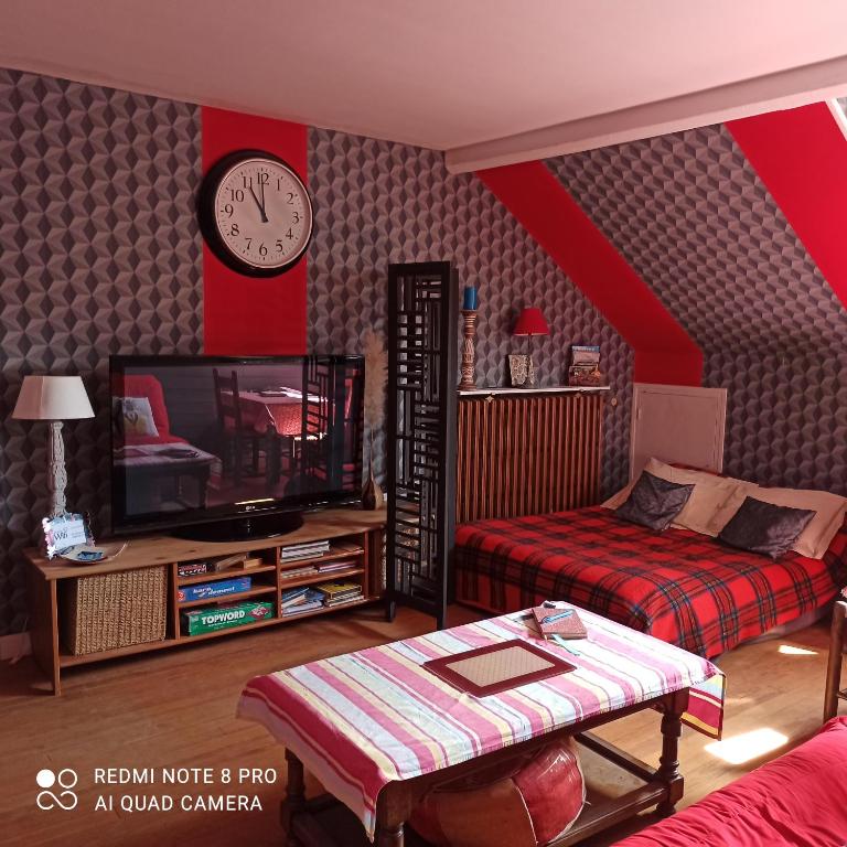 - un salon avec un lit et une horloge murale dans l'établissement PETIT APPARTEMENT 30M2, 3 lits, de 1 à 4 pers, à Neuilly