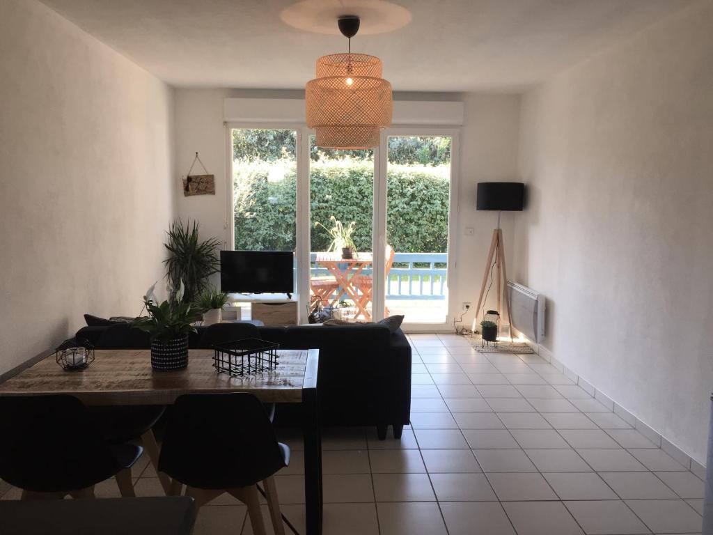 un salon avec une table et un canapé dans l'établissement Appartement 2 pièces à La Teste avec piscine, à La Teste-de-Buch