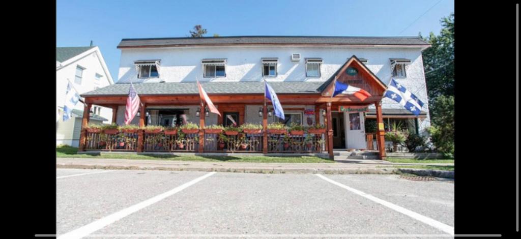 a building with flags in front of it at Auberge Restaurant du Monde in Nominingue