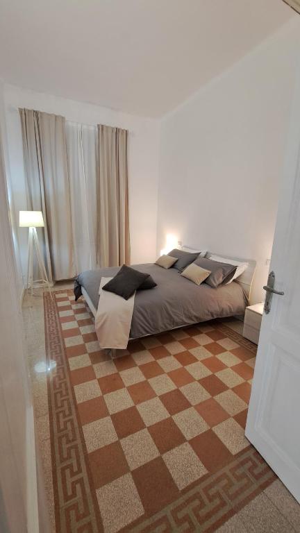 a bedroom with a bed and a checkered floor at Sea Vibes - Rome in Lido di Ostia