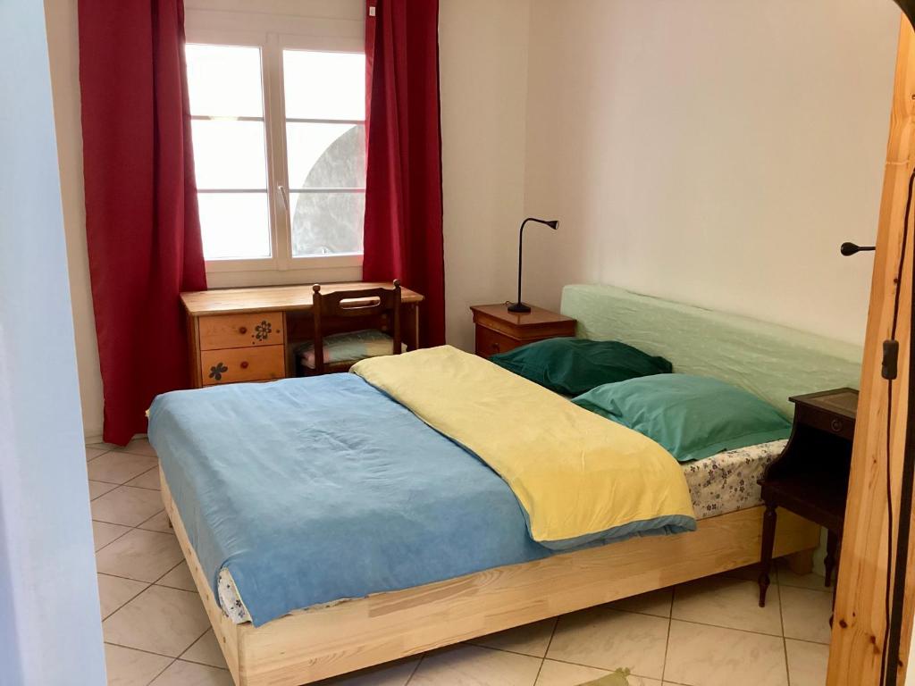- une chambre dotée d'un lit avec des draps bleus et jaunes dans l'établissement Appartment place d'équerre, à La Celle-sous-Gouzon