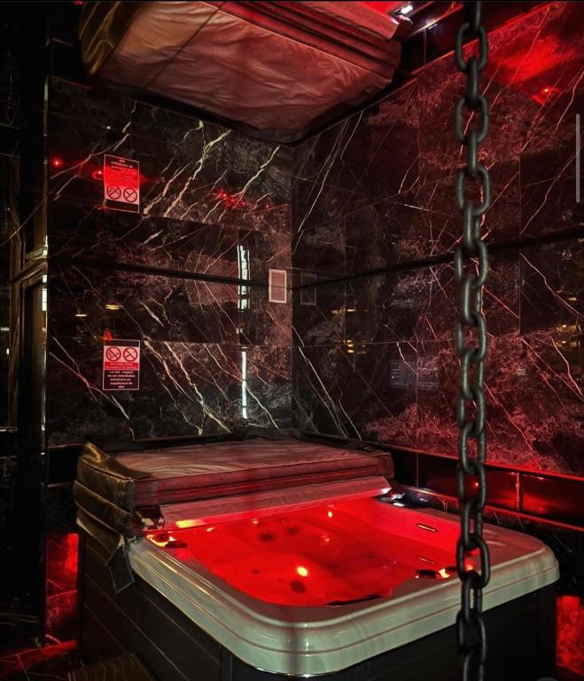 un lit rouge dans une pièce avec du sang rouge dessus dans l'établissement Love room - versace, à Montpellier