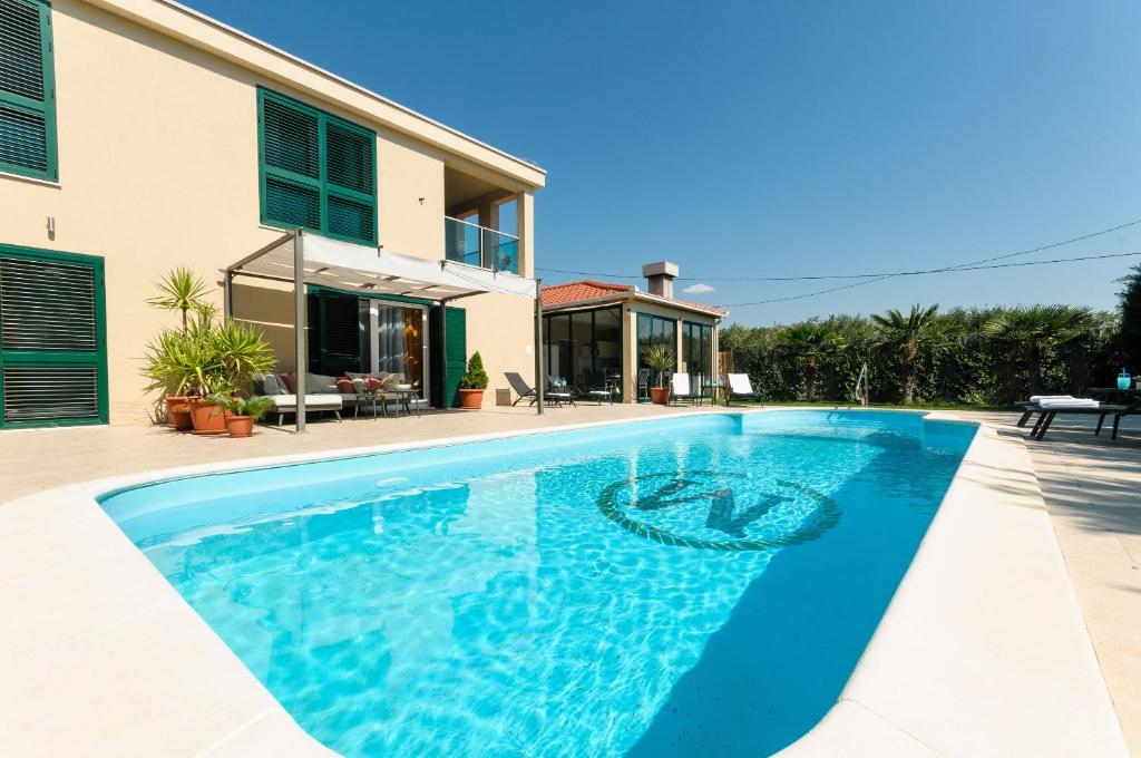 a swimming pool in front of a house at Villa Jolanda in Plano