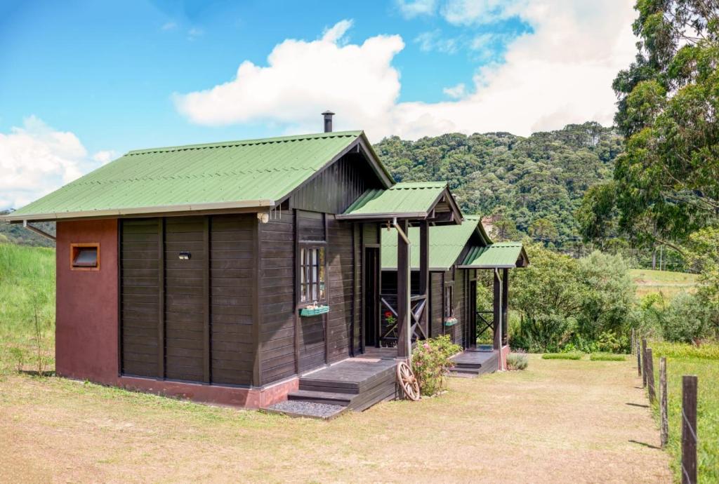 a small wooden house with a green roof at Chalé na Serra Urubici in Urubici