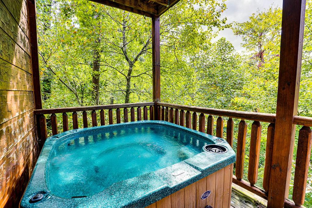 a jacuzzi tub on a porch of a cabin at Mountain Treasure by Venture Smoky Mountains in Sevierville