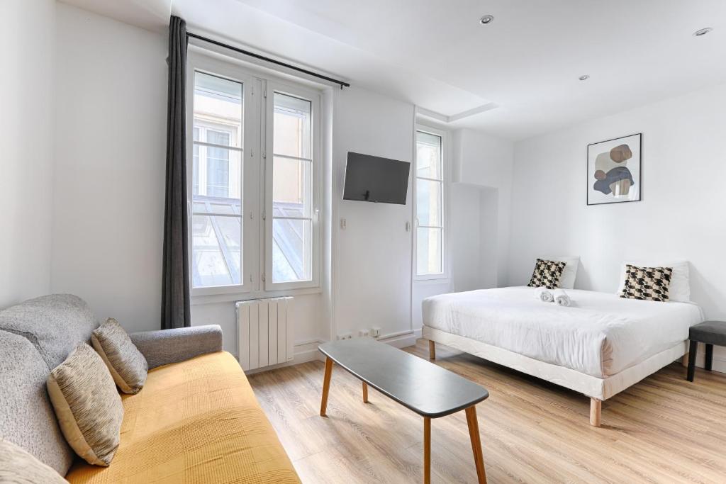 - une chambre blanche avec un lit et un canapé dans l'établissement Nazareth Sentier I Charming apartment 1BR 4P, à Paris