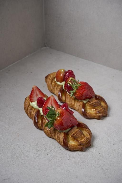 three croissants with strawberries on them on a table at Hotel Indonesia Kempinski Jakarta in Jakarta