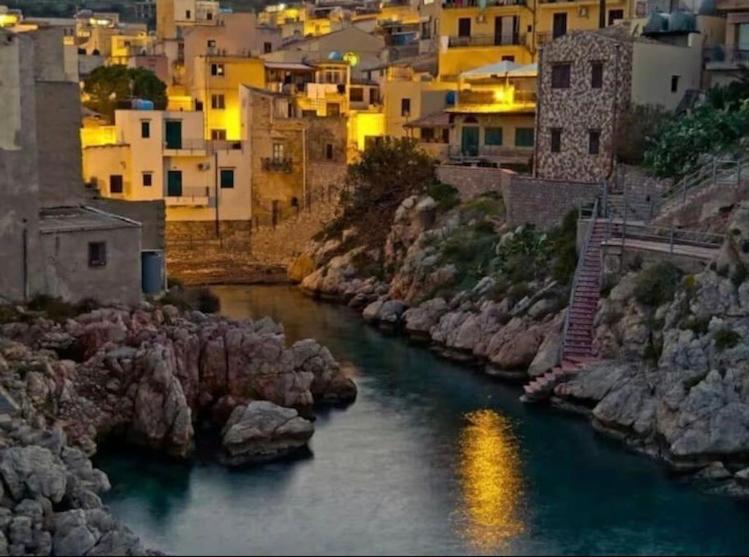 サンタ・フラーヴィアにあるLa casa dei Nonniの家屋・建物のある都市の川