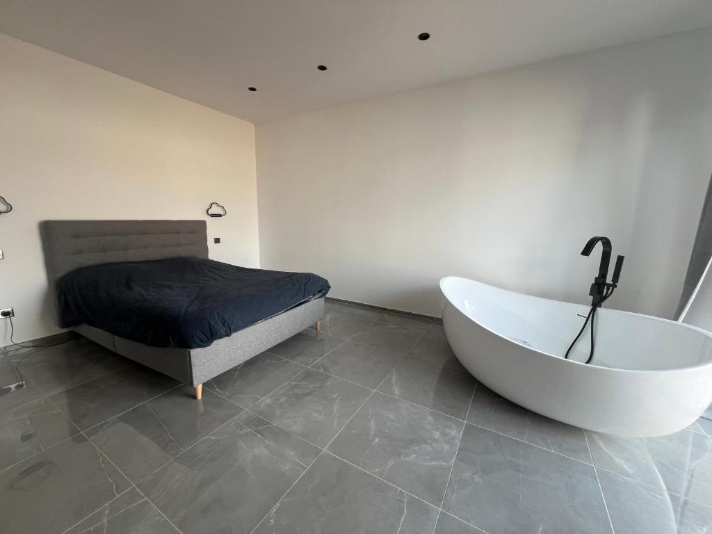 une chambre avec une baignoire et un lit et un lit dans l'établissement Maison 2 chambres, à Figari