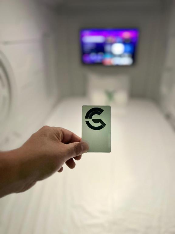 a hand holding up a sign with aazon logo on it at Green Caps in Cancún