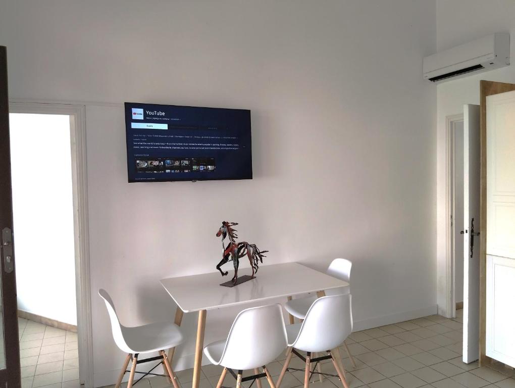 une salle à manger avec une table blanche et des chaises blanches dans l'établissement La mouette rieuse, à Saintes-Maries-de-la-Mer