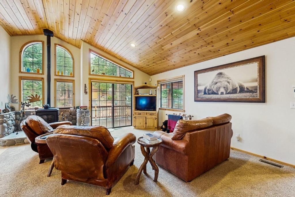 a living room with leather furniture and a tv at Chill on the Hill in Truckee