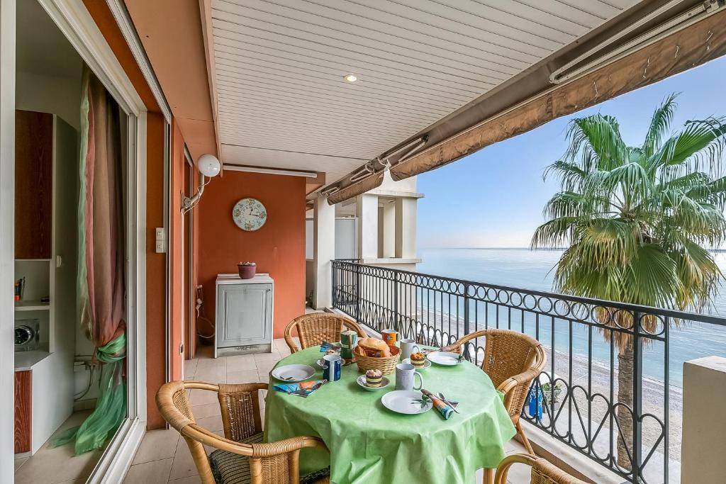 un balcon avec une table et des chaises et l'océan dans l'établissement Admiral Plaza Sea View - Happy Rentals, à Menton