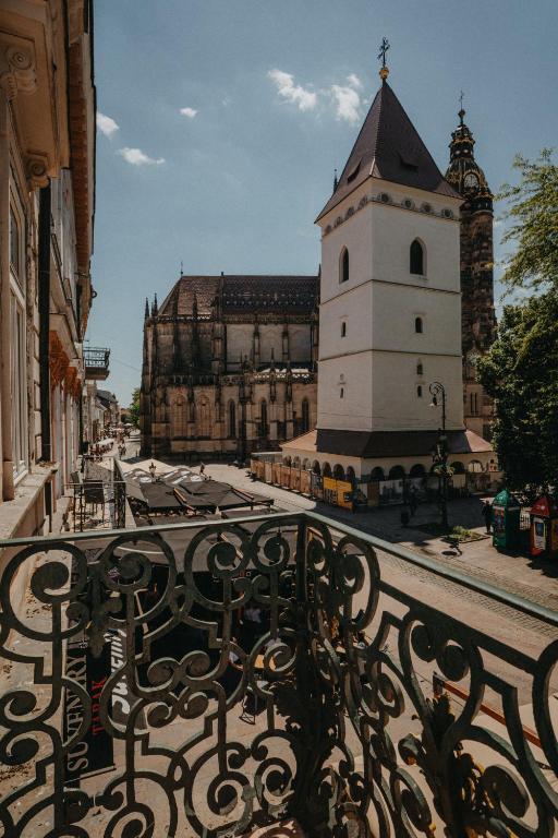 a building with a clock tower and a bench at Contessa Apartments in Košice