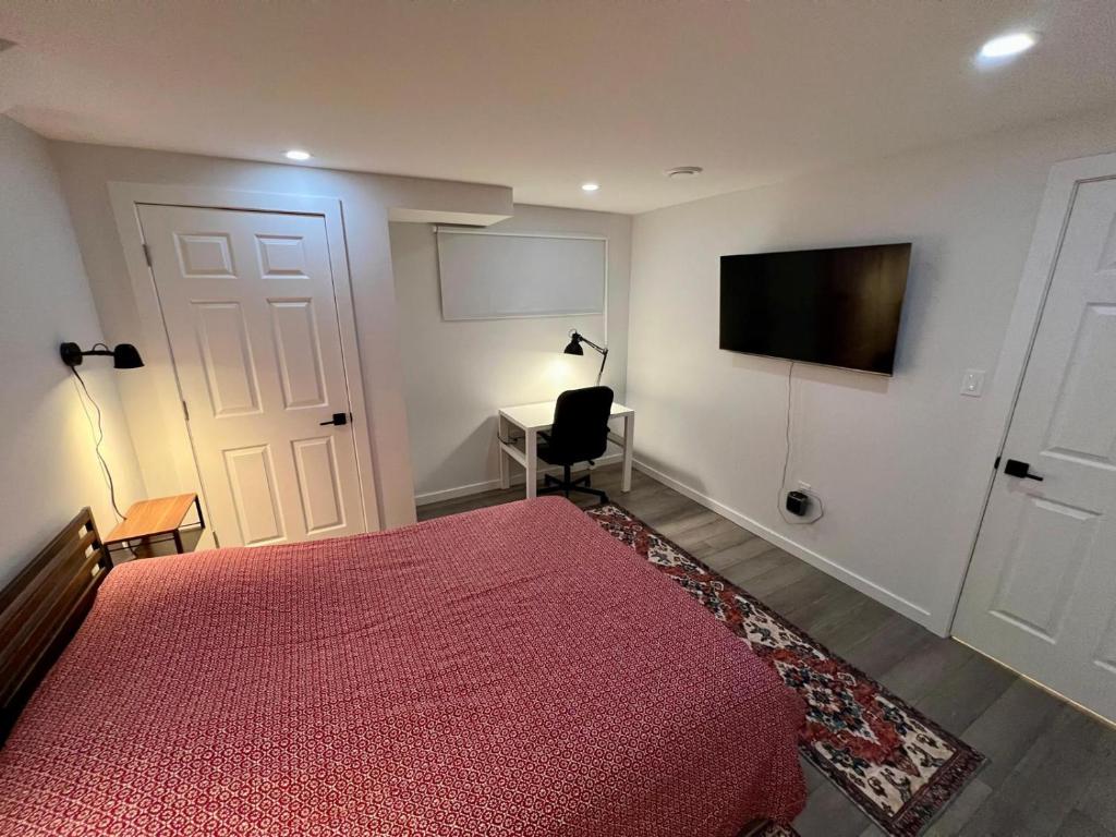 a bedroom with a bed and a desk and a television at Urban Nest by Guest Expertise in Winnipeg