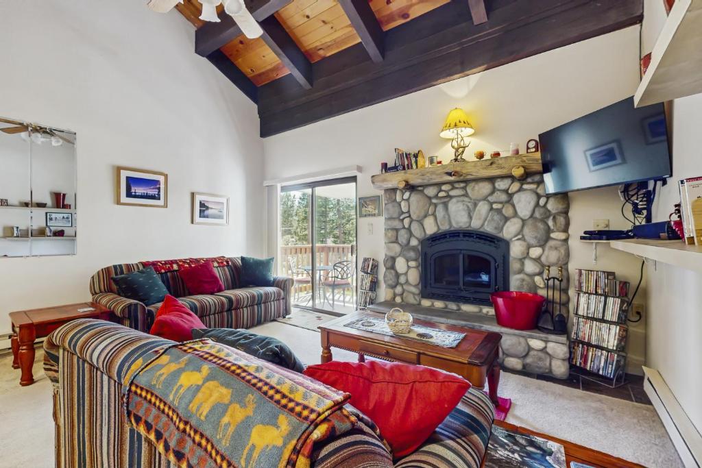 una sala de estar con sofás y una chimenea de piedra. en Woodstock and Snoopy, en Incline Village