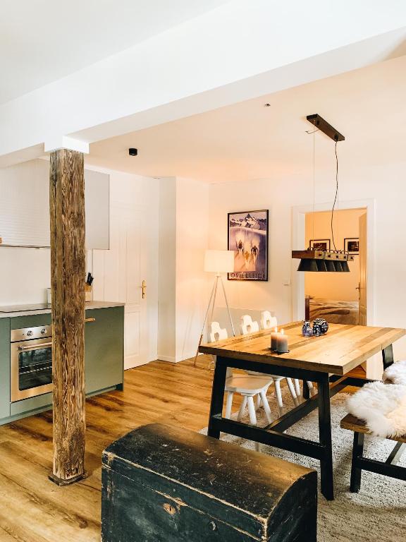 a kitchen and living room with a wooden table at Villakraft in Bad Gastein