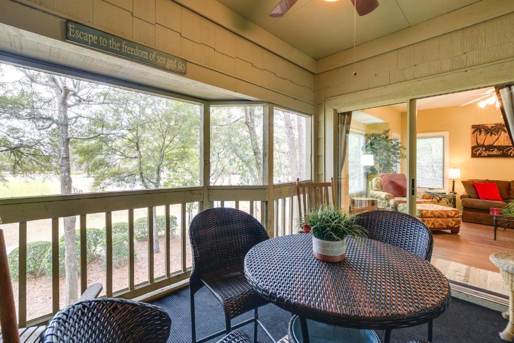 una veranda riparata con tavolo e sedie di Golf Course Home with Balcony in North Myrtle Beach! a North Myrtle Beach