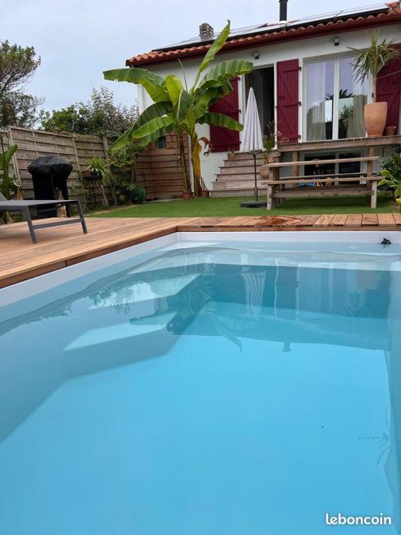 une piscine bleue devant une maison dans l'établissement Casa Ozeana, à Biarritz