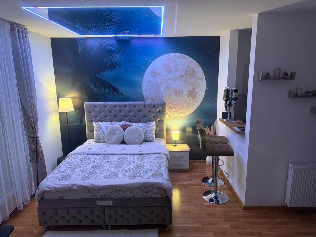 a bedroom with a bed with a moon mural on the wall at Secret Spa Nis in Niš