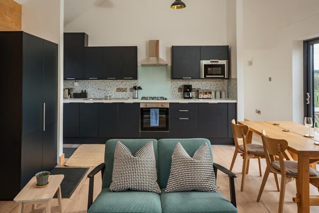 a living room with a blue couch and a kitchen at Willow Lodge in Six Road Ends