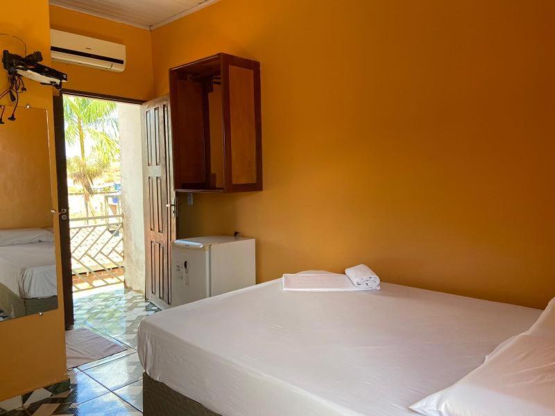 a room with two beds and a kitchen with a refrigerator at Junior Hotel in Anapu