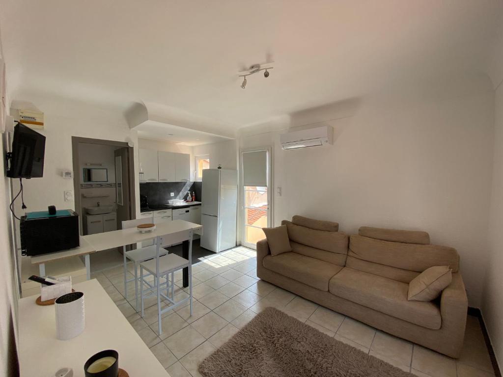 un salon avec un canapé et une cuisine dans l'établissement F3 patio bien situé, à Canet