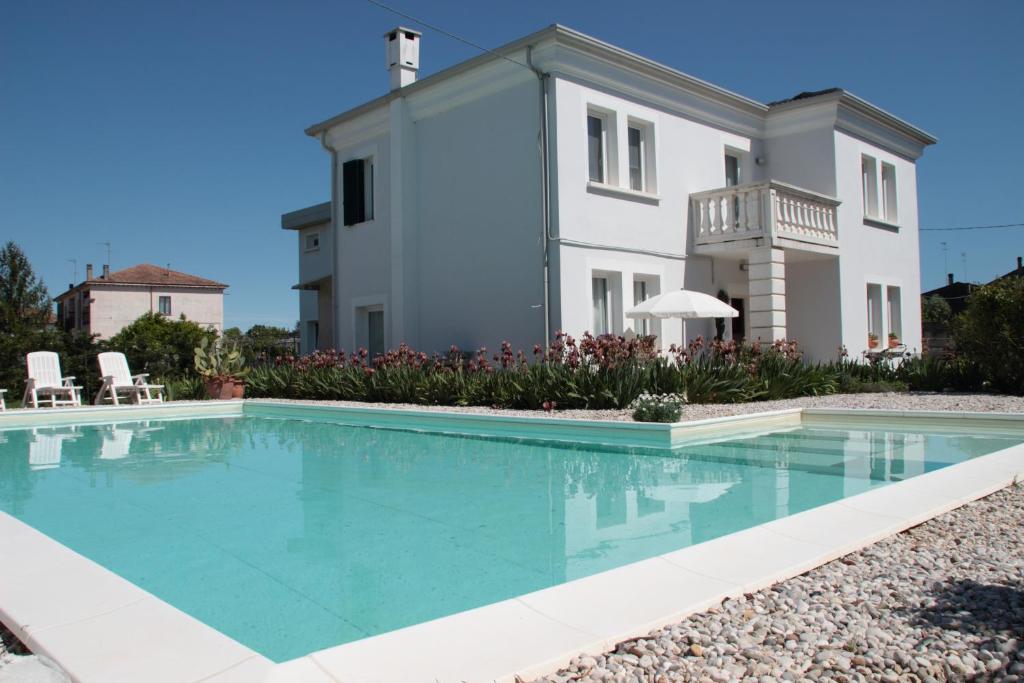 uma villa com piscina em frente a uma casa em Una Stanza nel Parco em Ariano nel Polesine
