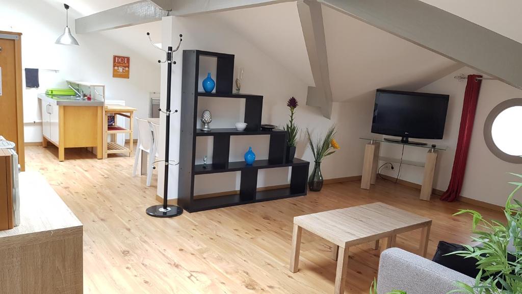 un salon avec une télévision et une table dans l'établissement L'escapade Landaise, Confort, Plage et Soleil, à Dax
