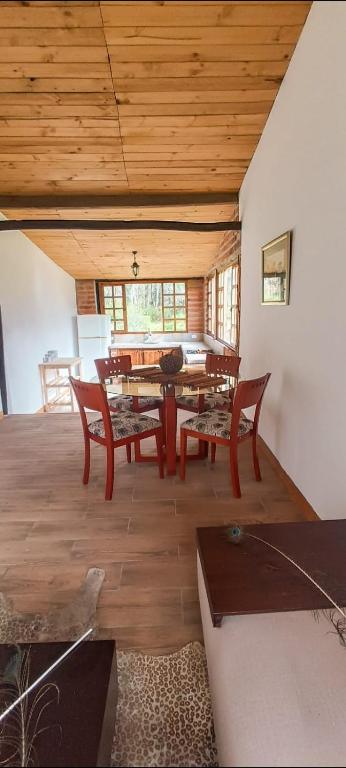 a dining room with a wooden table and chairs at Confortable cabaña campestre in Ibarra