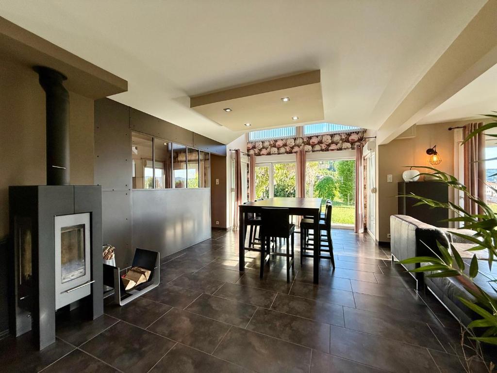 a living room with a table and a fireplace at Le Jardin de Rose et Capucine, piscine et jardin avec terrasse in Gérardmer
