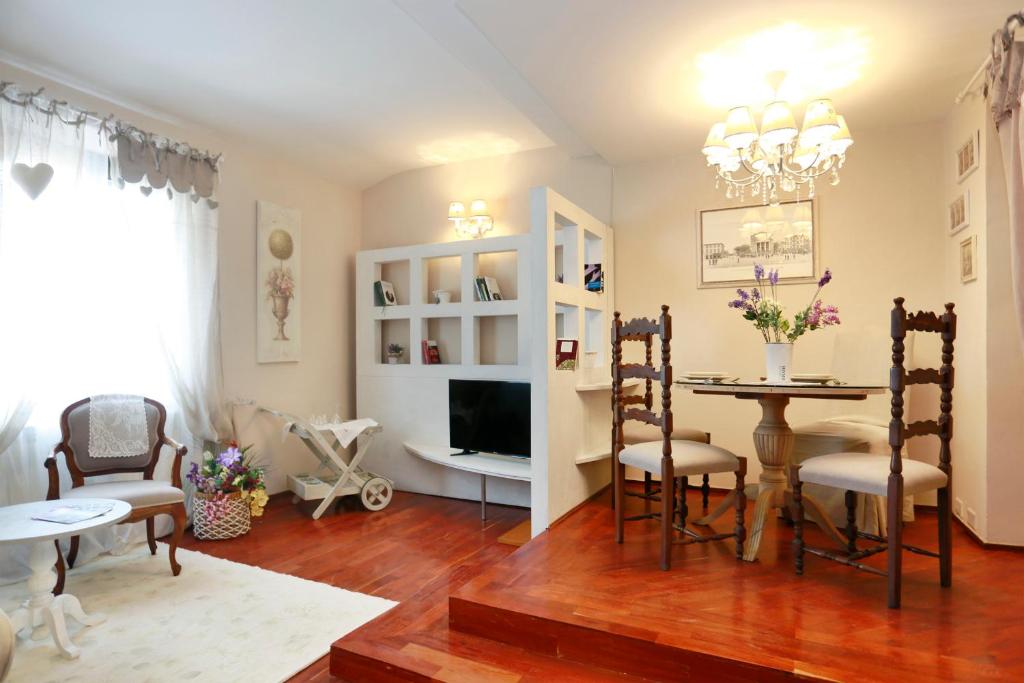 sala de estar con mesa, sillas y TV en Piero Apartments, en Montecatini Terme