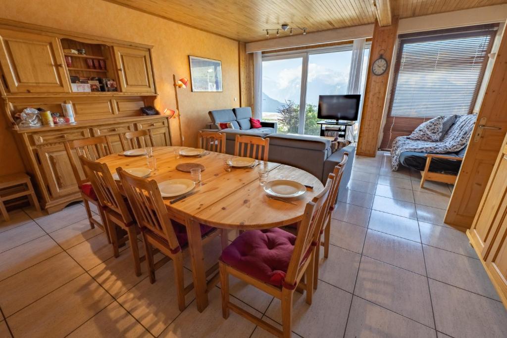 une salle à manger avec une table et des chaises en bois dans l'établissement Appartement 3 chambres, à Huez