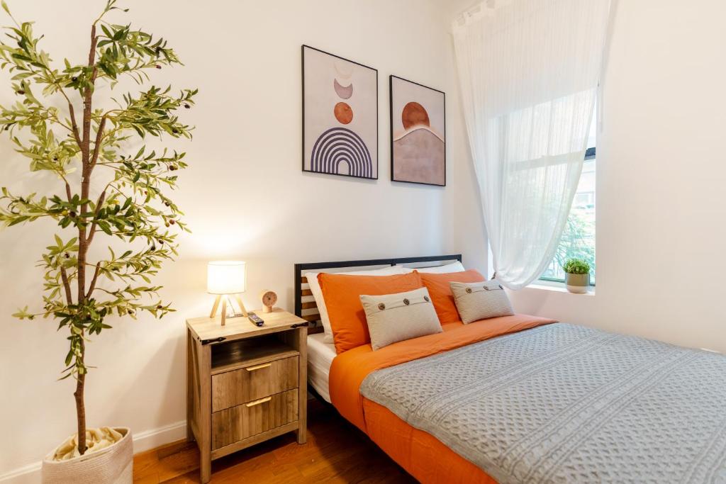 una camera da letto con un letto arancione e una pianta di Aura Style 3BD Suite at Times Square Manhattan a New York
