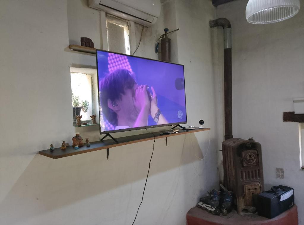 a flat screen tv on a shelf in a room at Mi tierra santa in La Porteña