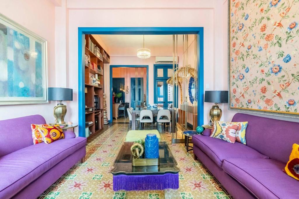 Una sala de estar con sofás morados y una mesa. en Stylish Colonial Townhouse in Santo Domingo's Historic Heart, en Santo Domingo