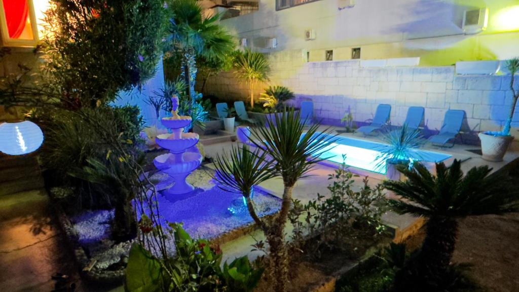 a swimming pool with chairs and plants in a building at Beach Villa Apartment on top location, with pool, sea view and exotic garden in Split