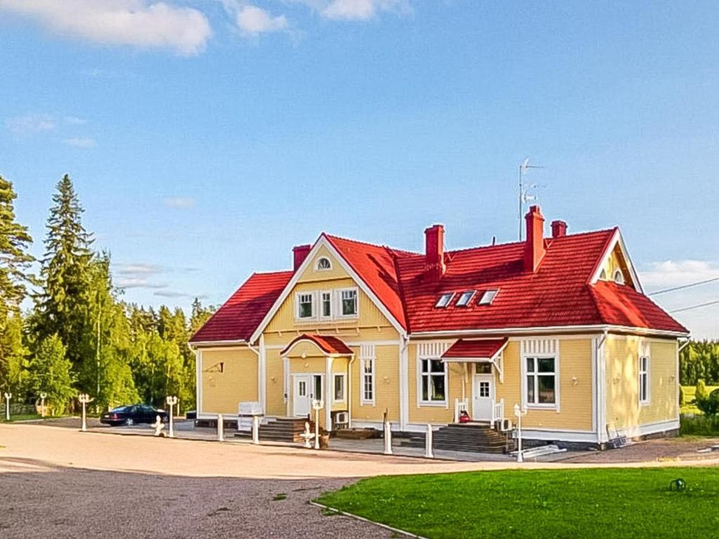 a house with a red roof on a street at Holiday Home Vilppulan huvila by Interhome in Suluslahti