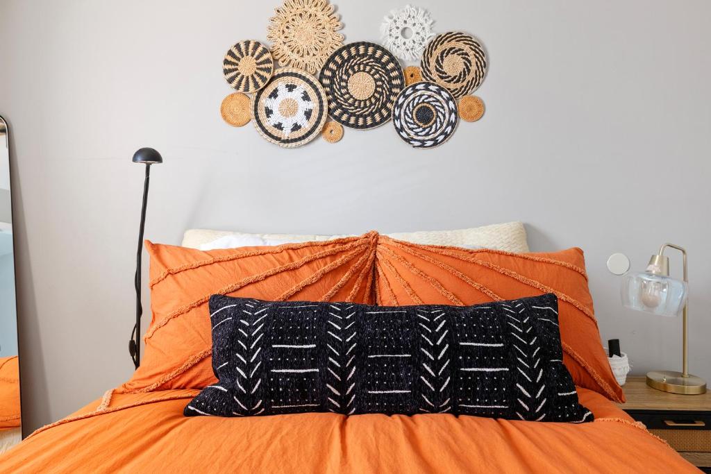 an orange bed with an orange pillow and plates on the wall at Private Room in Ballantyne in Charlotte